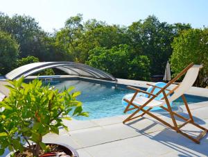 a chair sitting next to a swimming pool at Gîte de charme piscine privée à Martel in Martel