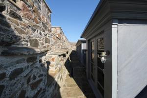 a stone building with a door and a wall at Mingary Castle - Restaurant with Rooms in Kilchoan