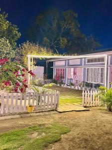 a white fence in front of a house with flowers at Sunny Villa in Sivasagar