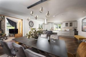 a dining room and living room with a table and chairs at Highfield Barton in Camborne