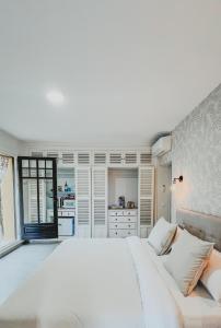 a white bedroom with a large bed and a kitchen at Seraphina Bookings Mojacar in Mojácar