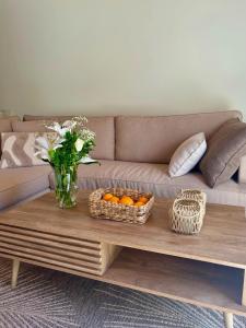 a living room with a couch and a table with oranges at Louloudi Apartment in Tsilivi