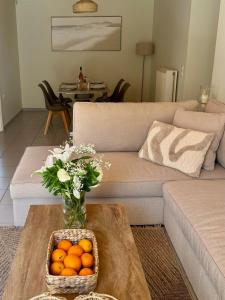 a living room with a couch and a basket of oranges at Louloudi Apartment in Tsilivi