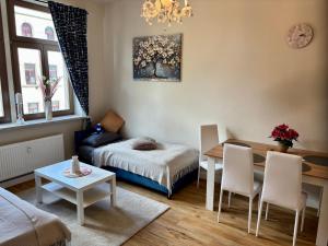 a living room with a bed and a table and chairs at Macabu Apartment Sophie in Zwickau