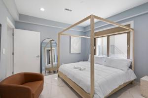 a bedroom with a canopy bed and a chair at Ammos Luxury Living- Zakinthos Suite in Ventnor City