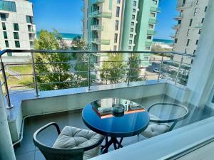 un balcón con una mesa azul y sillas. en Apartament Summerland Mamaia Nord, en Mamaia