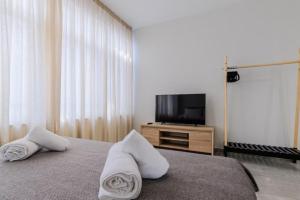 a bedroom with a bed with pillows and a television at Ladadika Vibes Studio 1 in Thessaloniki