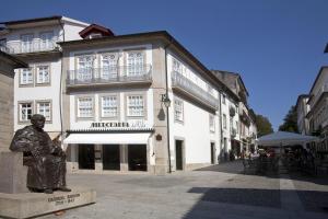 a building with a clock on the front of it at Mercearia da Vila in Ponte de Lima