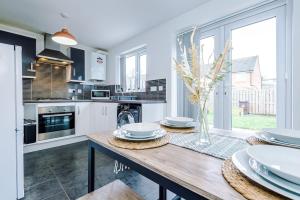 uma cozinha com uma mesa de madeira com placas em Steps from O2 Apollo, Ox road em Manchester