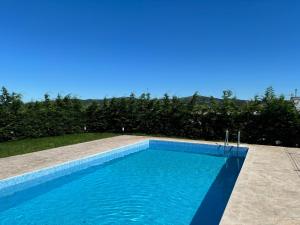 a swimming pool with blue water in a yard at AIR FERVENZA in Dumbría