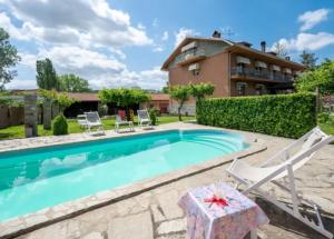 a swimming pool with chairs and a house at Cà 'd Gnese in Castagnole Lanze