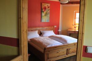 a bedroom with a bed with a red wall at Landhotel Kahrmühle in Pressath