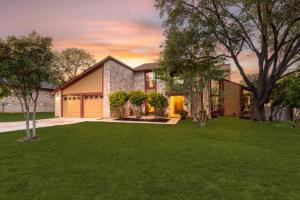 Una casa con un césped verde delante de ella. en Sleeps 18-Basketball Court-Pool-Playground-Games, en San Antonio
