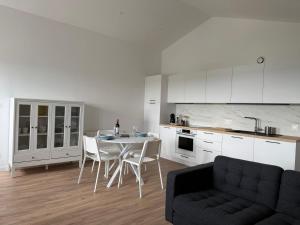 a kitchen with a table and chairs and a couch at ô Vignes & Bastides " L'échappée Lapébie ", appartement cosy in Sauveterre-de-Guyenne