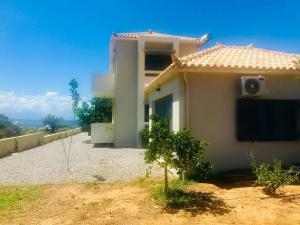 a small white house with a roof at A designed loft studio a minute walk to the beach in Archangelos
