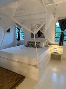 ワタムにあるVilla Amaliaのベッドルーム(天蓋付き白いベッド1台付)
