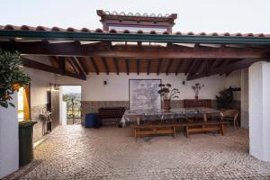 a patio with a table and benches in a building at Casa Benny Countryside Guesthouse CENTER PORTUGAL in Hombres