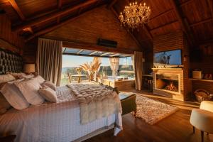 a bedroom with a large bed and a fireplace at Morada Valente in Gramado +24 photos