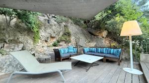 patio z krzesłami, kanapą i stołem w obiekcie Le cabanon du Faron une chambre d hote dans un jardin w mieście Tulon +10 zdjęć