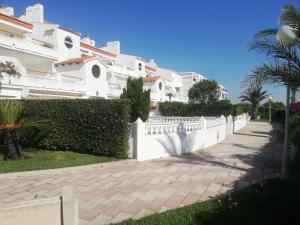 une clôture blanche devant une maison dans l'établissement Voramar Serviplaya Solo Familias, à Casas Las Basas
