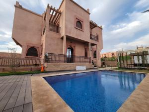 a house with a swimming pool in front of it at Villa Marrakech Rimass - 6 Chambres Dont 4 Suites Luxe, Piscine Privee & Jardins in Marrakesh