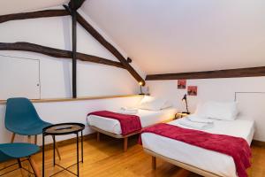 a bedroom with two beds and a blue chair at Douro View House Ribeira in Porto