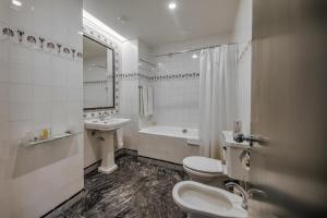 a bathroom with two toilets and a sink and a shower at Hotel Metropole in Lisbon
