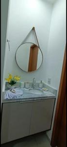 ein Badezimmer mit Waschbecken und Spiegel in der Unterkunft Studio Nossa Senhora Aparecida - Condominium of Faith in Cachoeira Paulista