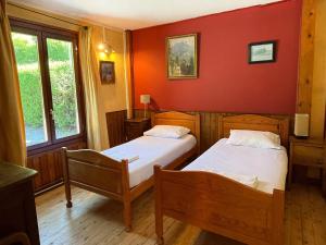 two beds in a room with red walls at Chalet les pieds dans l'eau avec accès direct au Lac d'Annecy in Angon +7 photos