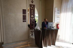 a man standing at a reception desk in a room at فندق أناف in Al Madinah