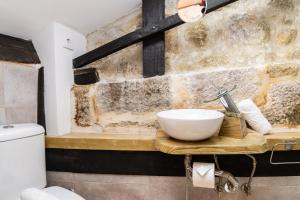 a bathroom with a bowl sink on a wooden counter at Douro View House Ribeira in Porto