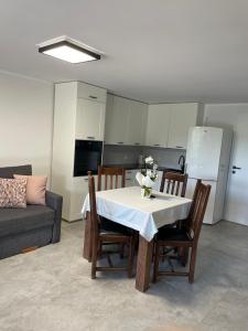a living room with a table and chairs and a kitchen at Apartament Malinowe Wzgórze in Krzeszna