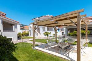 a patio with a table and chairs under a pergola at Pelago Loft in Limenas