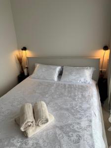 a bed with two towels and two pillows on it at Mano Jūra - apartamentų nuoma Mano Jūra 3 kvartale in Palanga +18 photos