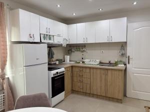 a kitchen with white appliances and wooden cabinets at Cozy Family House in Lazarevac