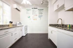 a white kitchen with white cabinets and a sink at Coconut Palm in Key West