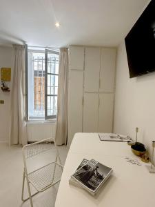 a white room with a table with a magazine on it at Maison de Charme Centre Roquette, 3 chambres in Arles