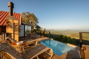 a deck with a pool and a table and chairs at Morada Valente in Gramado