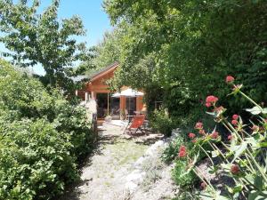 布里昂松Petit chalet neuf indépendant 2 pers "La cabane de Jean "的种满鲜花和树木的花园