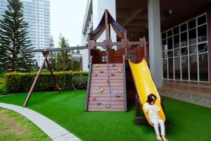a playground with a slide and a girl sitting on it at Casa Eden in Tagaytay