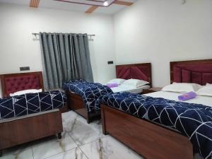 a room with three beds in a room at Hotel Grand View in Barkot