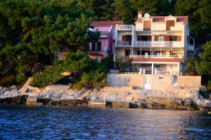 a house on the shore of a body of water at Apartmani Srdjana in Prizba