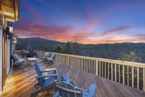 une terrasse avec des chaises, une table et un coucher de soleil dans l'établissement Van Kirk Cove - 6 BDR Stunner, à Branson West