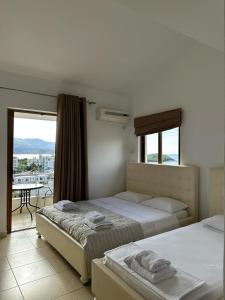 a bedroom with two beds and a balcony with a view at Hotel Marku in Ksamil