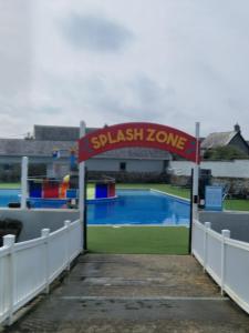 a gate to a swimming pool with a playground at Bude Holiday Resort Peace And Quiet in Bude