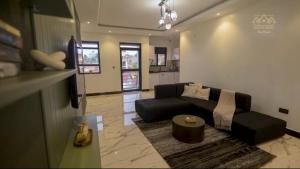 Kampala Apartments في كامبالا: غرفة معيشة بها أريكة وطاولة