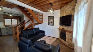a living room with a couch and a television at Chalé Coração de Monte Verde in Monte Verde