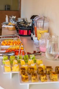 a counter with several plates of food on it at Pousada Recanto de Ponta Negra in Natal