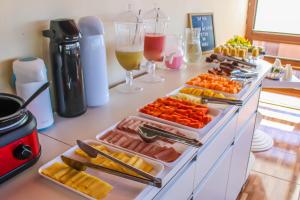 a buffet with several trays of food and drinks at Pousada Recanto de Ponta Negra in Natal +51 photos