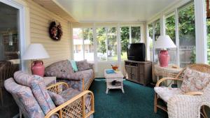 a screened in porch with chairs and a tv at 12 Mechanic St in West Cape May